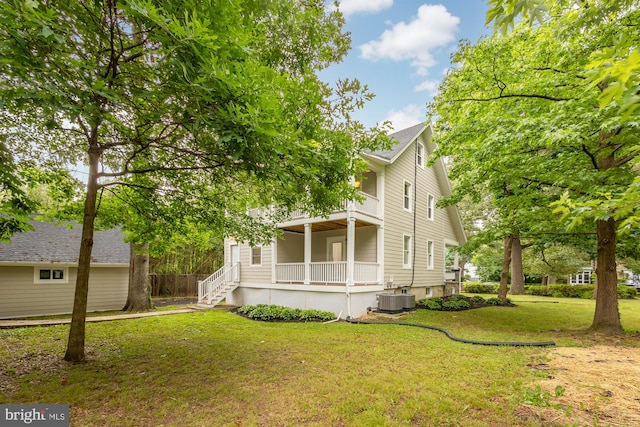 exterior space featuring cooling unit, a balcony, and a front lawn