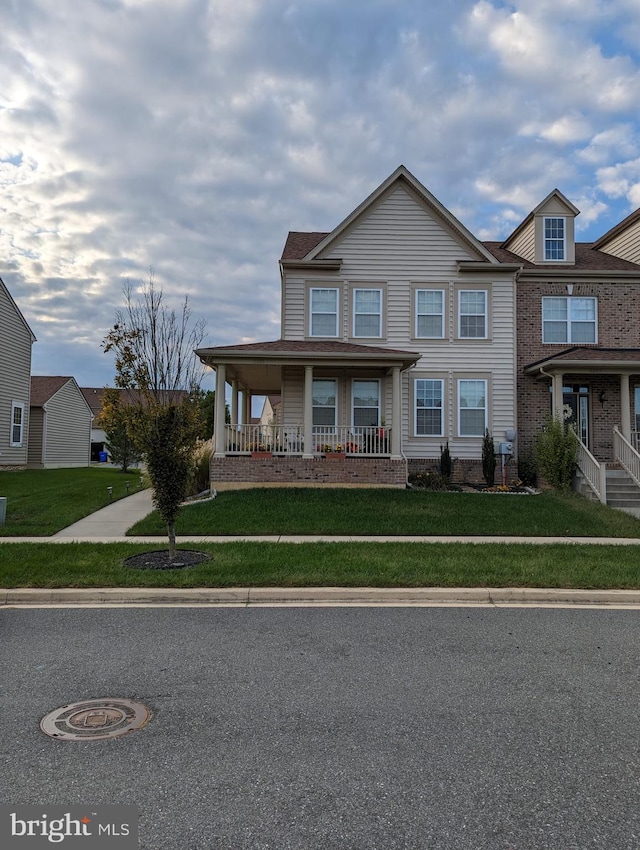 view of front of house featuring covered porch and a front lawn