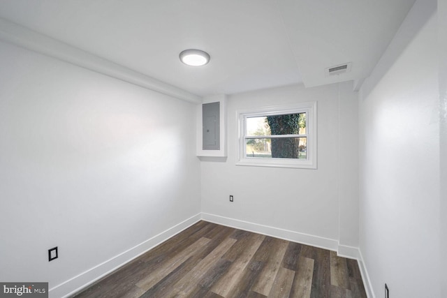 spare room with dark hardwood / wood-style flooring and electric panel