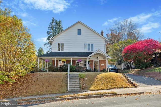 629 Wises Mill Rd, Philadelphia, PA 19128 - farmhouse-style home with a chimney, brick siding, covered porch, stairs, and aphalt driveway