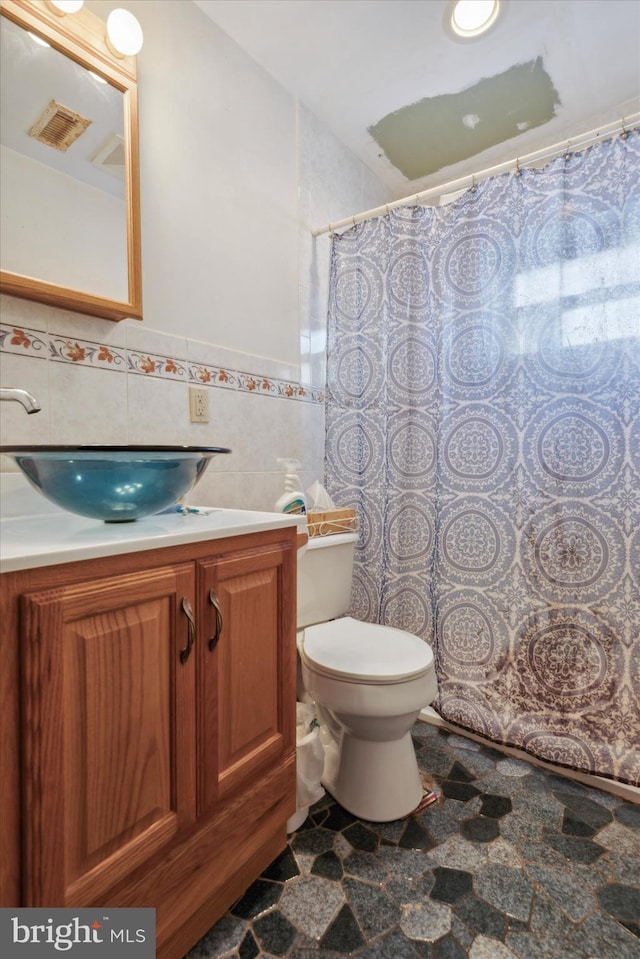 bathroom featuring tile walls, vanity, a shower with shower curtain, and toilet