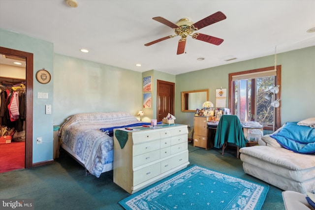 carpeted bedroom featuring a walk in closet, a closet, and ceiling fan