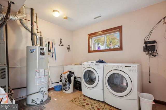 washroom featuring tile patterned floors, washing machine and dryer, and water heater