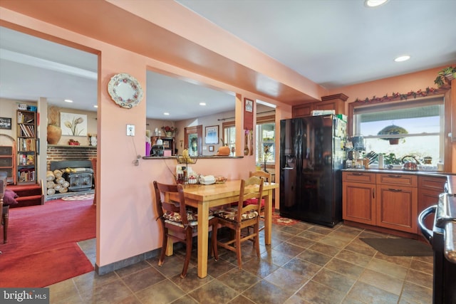 kitchen with black refrigerator with ice dispenser and stainless steel range