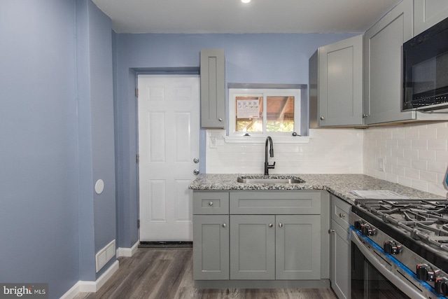 kitchen featuring gray cabinets, dark hardwood / wood-style floors, sink, and light stone counters