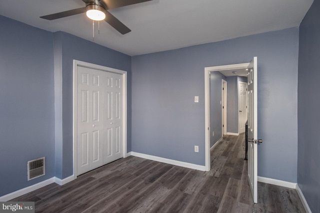 unfurnished bedroom featuring dark hardwood / wood-style flooring, a closet, and ceiling fan