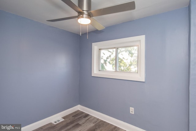 empty room with ceiling fan and dark hardwood / wood-style flooring