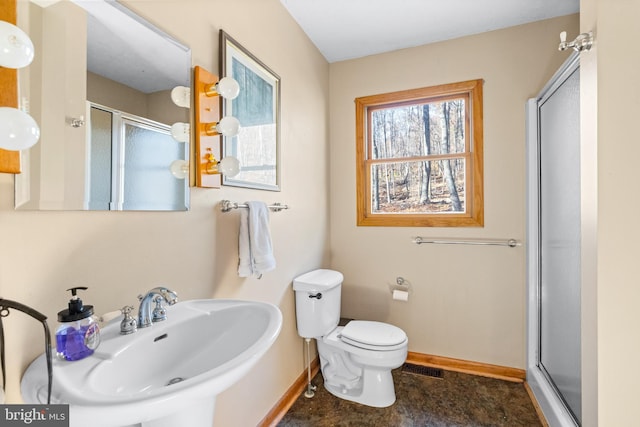 bathroom with sink, toilet, and a shower with door