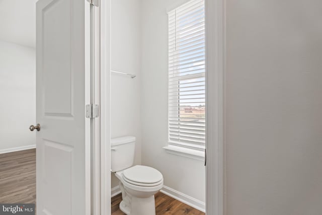 bathroom with toilet and hardwood / wood-style flooring