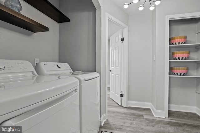 laundry room with separate washer and dryer, a notable chandelier, and light wood-type flooring