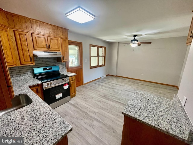 kitchen with backsplash, light stone countertops, light wood-type flooring, and stainless steel range with electric cooktop