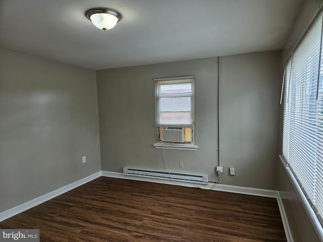 spare room with cooling unit, baseboard heating, and dark hardwood / wood-style flooring