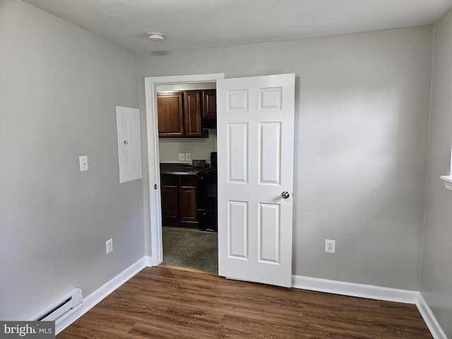 interior space featuring dark hardwood / wood-style floors, electric panel, and a baseboard radiator