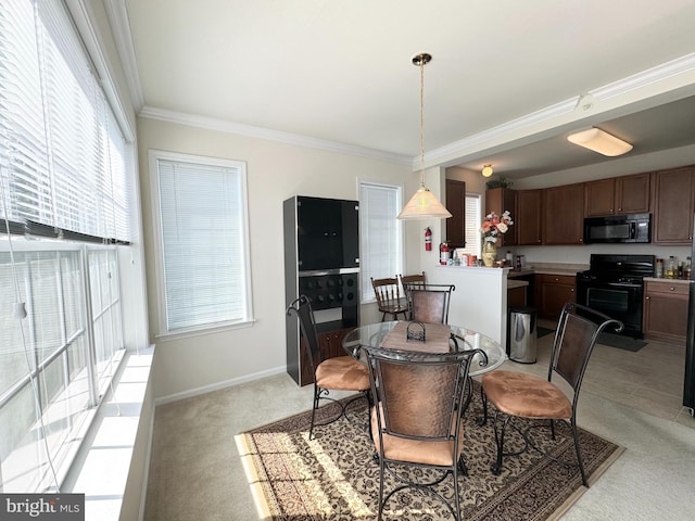 carpeted dining space with a healthy amount of sunlight and crown molding