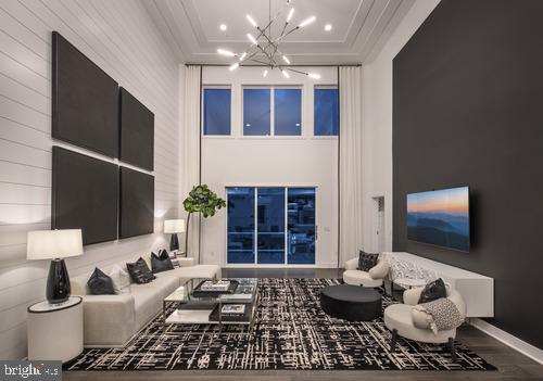 living room featuring ornamental molding, wood-type flooring, and an inviting chandelier