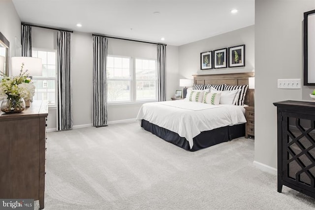 bedroom featuring light carpet and multiple windows