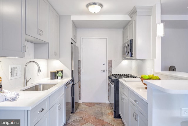 kitchen featuring decorative light fixtures, stainless steel appliances, sink, and backsplash