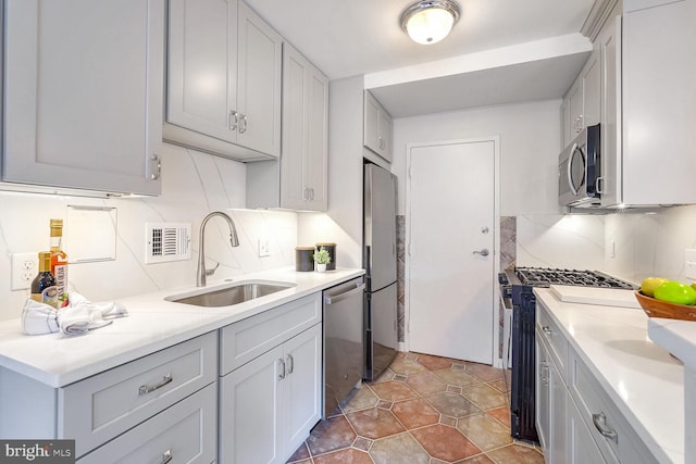 kitchen featuring light tile patterned floors, tasteful backsplash, appliances with stainless steel finishes, and sink