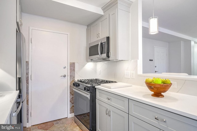 kitchen featuring tasteful backsplash, stainless steel appliances, hanging light fixtures, and light tile patterned floors