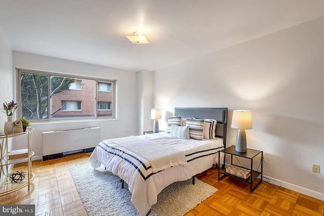 bedroom featuring light parquet flooring and radiator