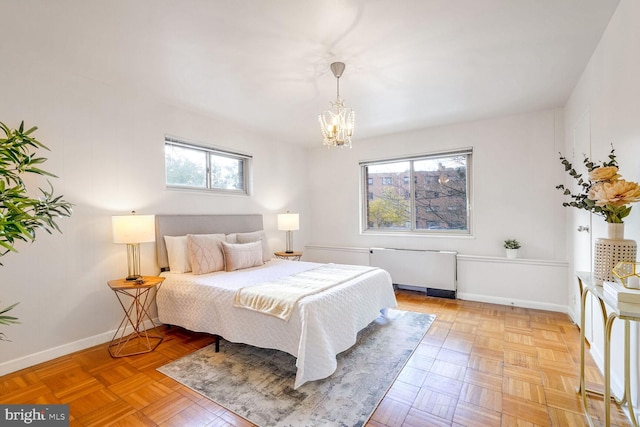 bedroom featuring a notable chandelier, multiple windows, radiator heating unit, and light parquet floors