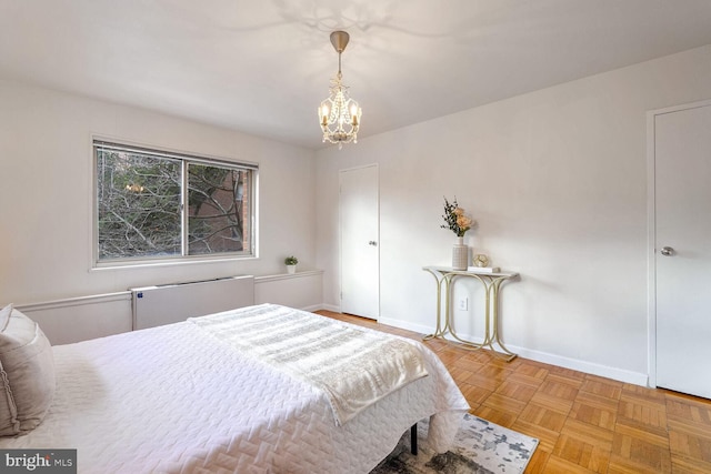 bedroom with light parquet flooring, radiator heating unit, and an inviting chandelier