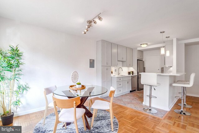 dining area featuring light parquet flooring and sink