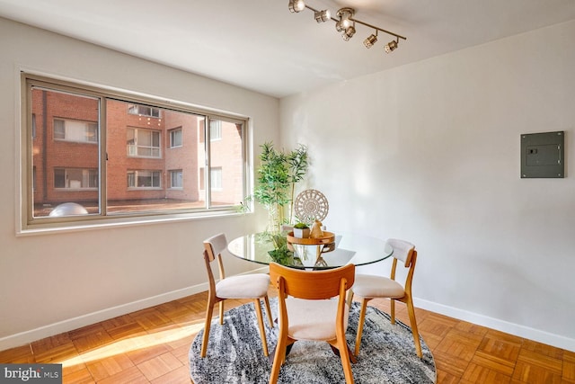 dining space with parquet floors and electric panel