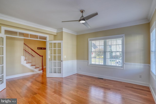 empty room with light hardwood / wood-style floors, french doors, and crown molding