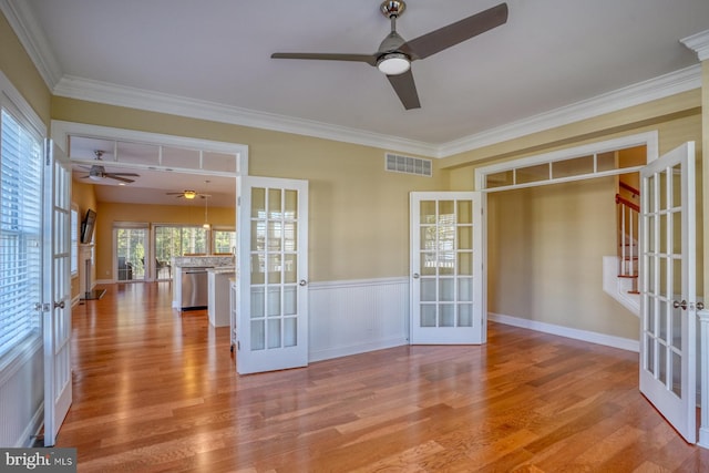 spare room with french doors, crown molding, and light wood-type flooring