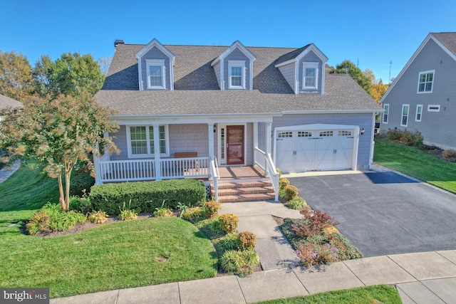 new england style home with a porch, a front lawn, and a garage