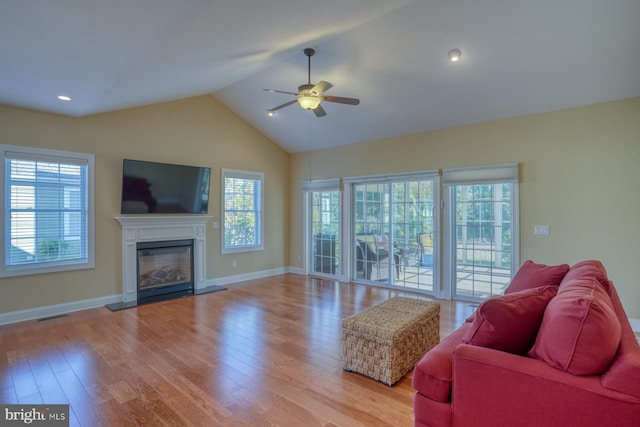 living room with vaulted ceiling, light wood-type flooring, and a healthy amount of sunlight