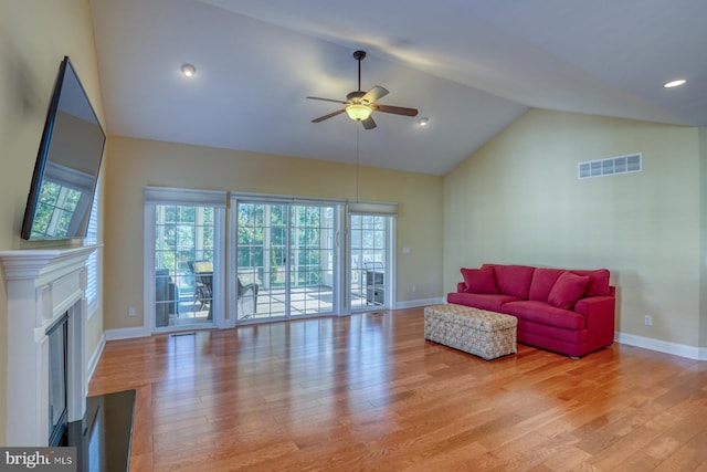 living room with high vaulted ceiling, light hardwood / wood-style floors, and plenty of natural light