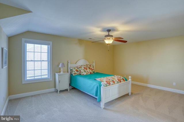 bedroom featuring ceiling fan, light carpet, and vaulted ceiling