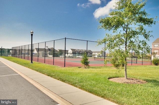 view of tennis court with a lawn