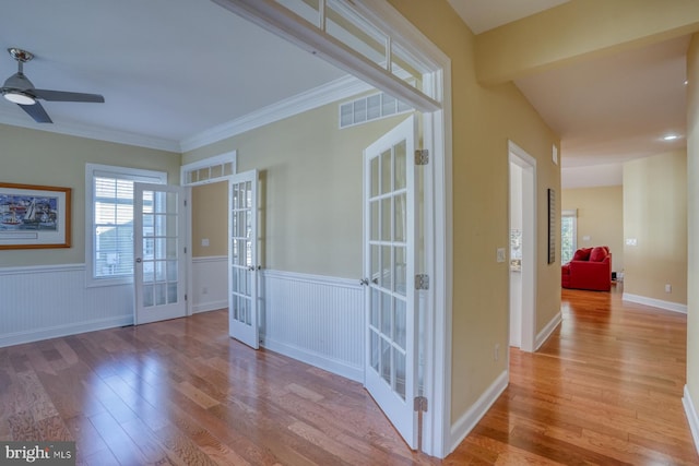 interior space with french doors, crown molding, light hardwood / wood-style flooring, and ceiling fan