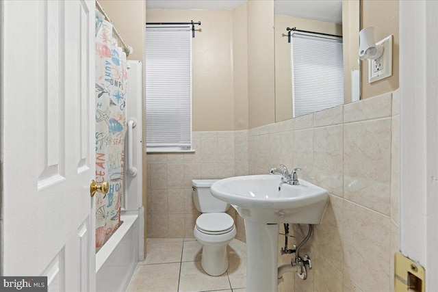 bathroom featuring toilet, tile walls, shower / tub combo, and tile patterned flooring