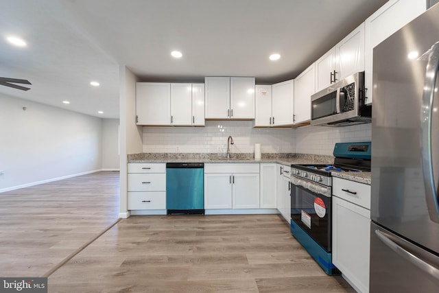 kitchen featuring appliances with stainless steel finishes, light stone counters, and white cabinetry