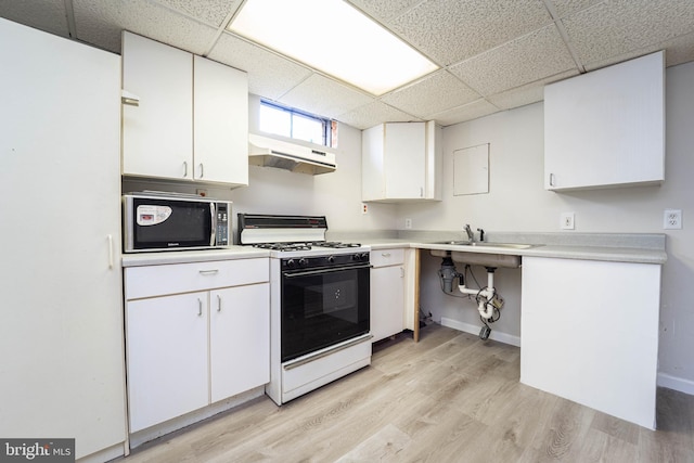 kitchen with white cabinetry, a paneled ceiling, white gas stove, and light hardwood / wood-style floors