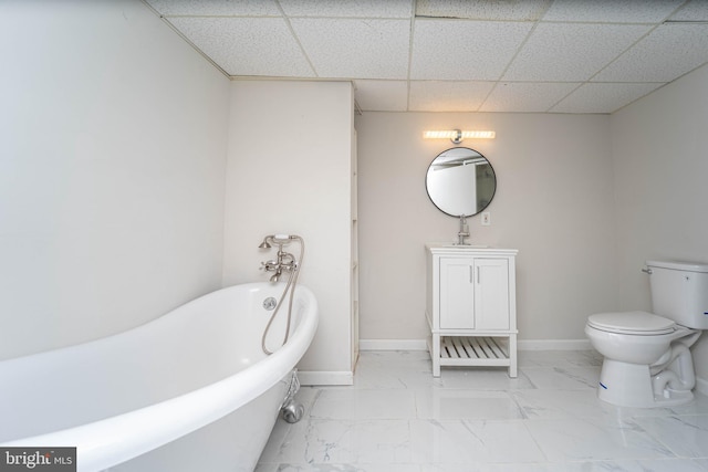 bathroom featuring vanity, toilet, a drop ceiling, and a bathing tub