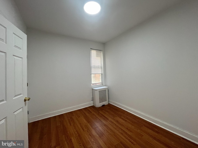 empty room with dark hardwood / wood-style flooring