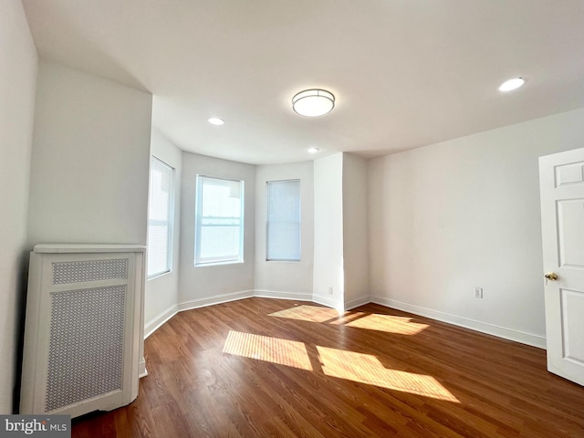 unfurnished living room with hardwood / wood-style floors and radiator