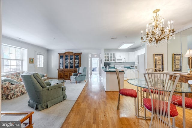 living room with a notable chandelier, light hardwood / wood-style floors, and sink