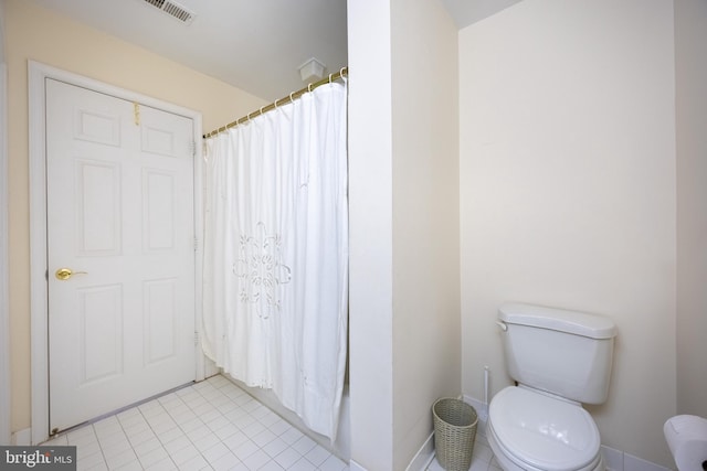 bathroom featuring tile patterned flooring, curtained shower, and toilet