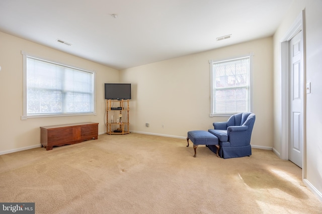 sitting room featuring light carpet