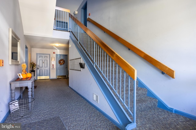 stairway with carpet flooring and a towering ceiling