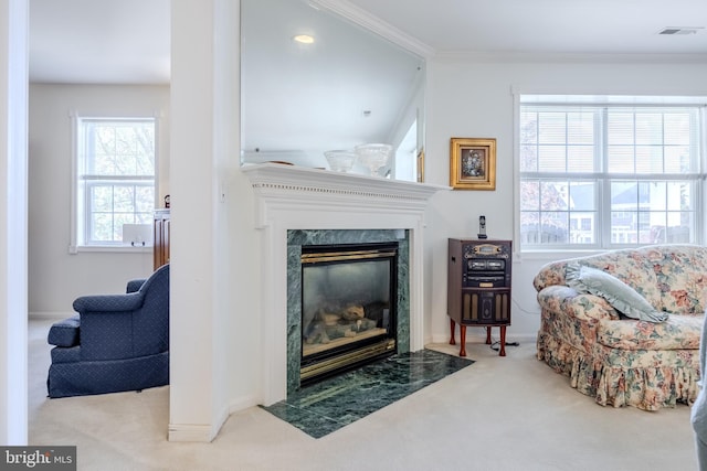 sitting room with light carpet and a high end fireplace