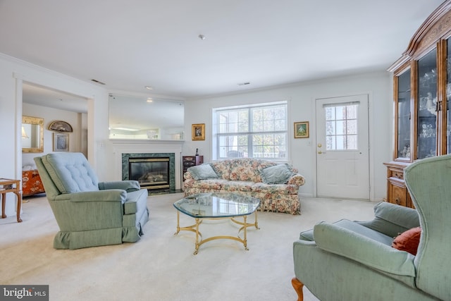 living room with light colored carpet, ornamental molding, and a high end fireplace