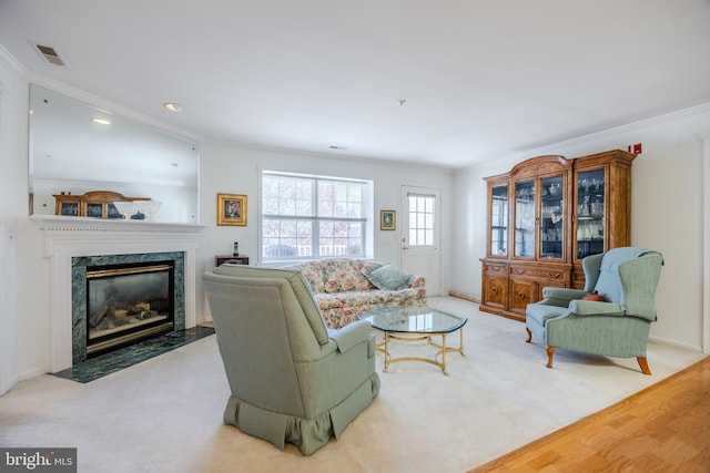 living room featuring light hardwood / wood-style floors, crown molding, and a premium fireplace