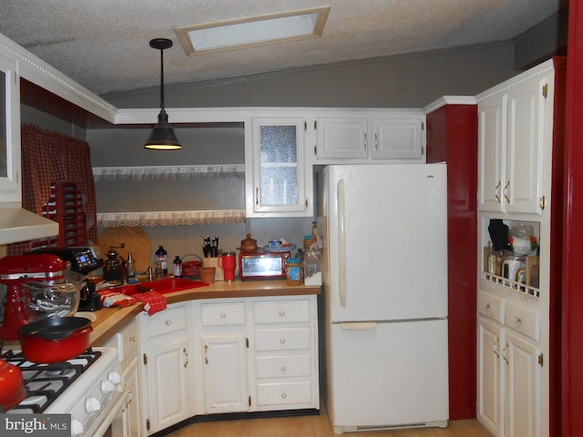 kitchen featuring a textured ceiling, white appliances, decorative light fixtures, white cabinets, and lofted ceiling